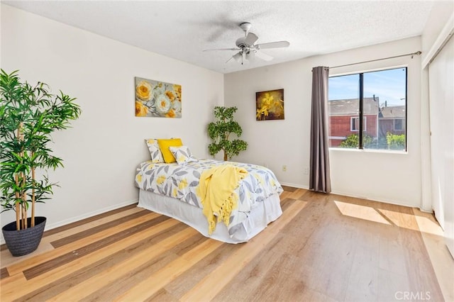 309 N Raitt St Unit C, Santa Ana, CA 92703 - bedroom featuring light wood-style flooring, baseboards, a textured ceiling, and a ceiling fan