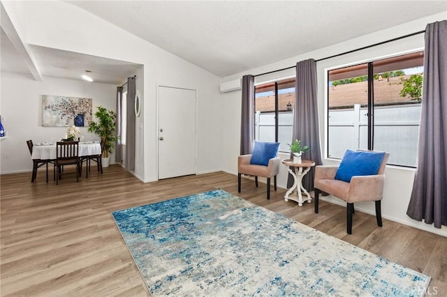 309 N Raitt St Unit C, Santa Ana, CA 92703 - sitting room featuring vaulted ceiling, light wood-style flooring, baseboards, and a wall unit AC