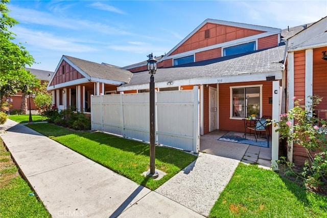 309 N Raitt St Unit C, Santa Ana, CA 92703 - view of side of home featuring a shingled roof, board and batten siding, and an attached garage