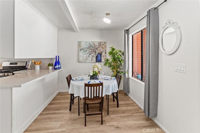 309 N Raitt St Unit C, Santa Ana, CA 92703 - dining space featuring a textured ceiling, light wood-style floors, and baseboards