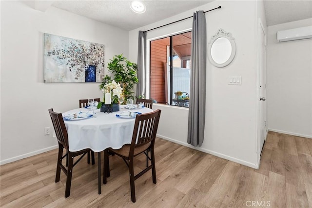 309 N Raitt St Unit C, Santa Ana, CA 92703 - dining room with a textured ceiling, light wood-style flooring, a wall mounted AC, and baseboards