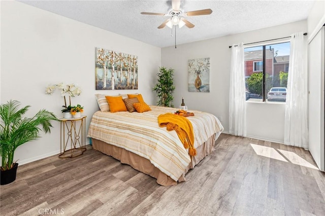 309 N Raitt St Unit C, Santa Ana, CA 92703 - bedroom with light wood-style flooring, a textured ceiling, baseboards, and a ceiling fan