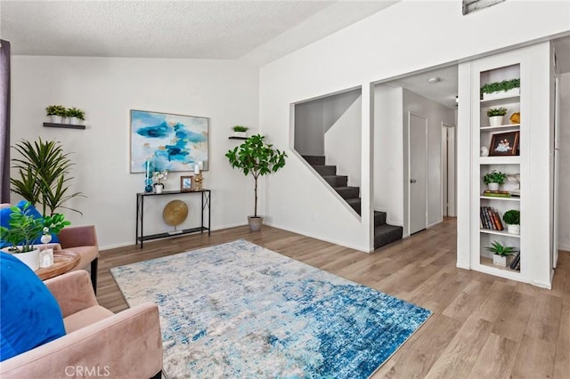 309 N Raitt St Unit C, Santa Ana, CA 92703 - living area featuring wood finished floors, stairs, a textured ceiling, lofted ceiling, and baseboards