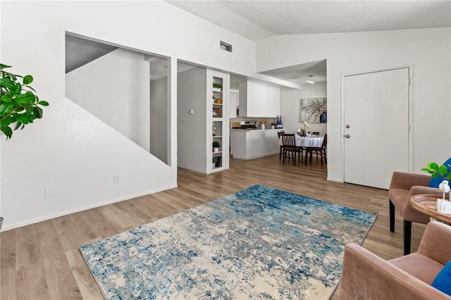309 N Raitt St Unit C, Santa Ana, CA 92703 - living area featuring vaulted ceiling, wood finished floors, and a textured ceiling