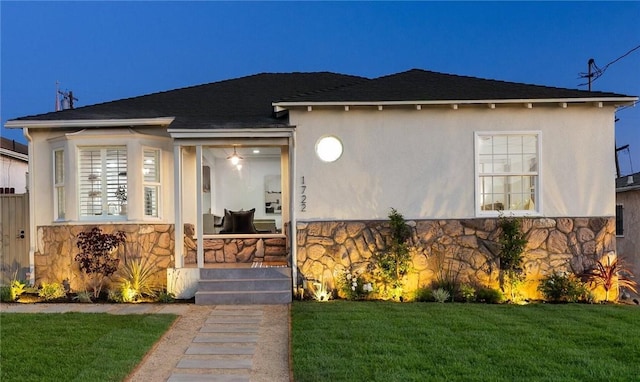 1722 W 107th St, Los Angeles, CA 90047 - view of front of house featuring stone siding, a front yard, and stucco siding