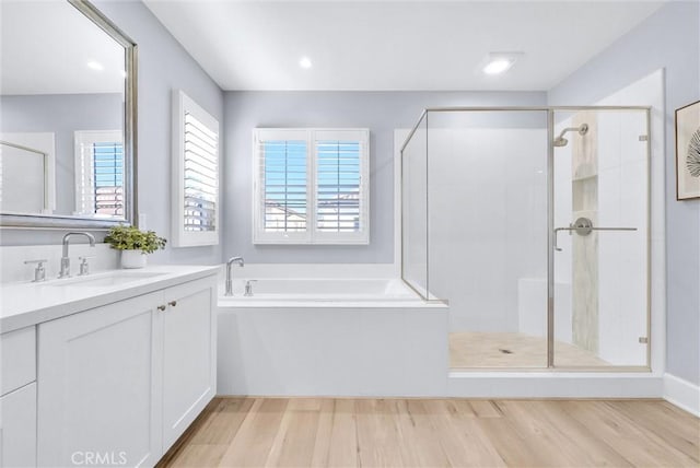 211 Fiore, Irvine, CA 92602 - bathroom with vanity, a garden tub, wood finished floors, a shower stall, and recessed lighting