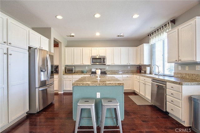 39883 S Creek Cir, Murrieta, CA 92563 - kitchen with stainless steel appliances, a kitchen island, a sink, dark wood-style flooring, and recessed lighting