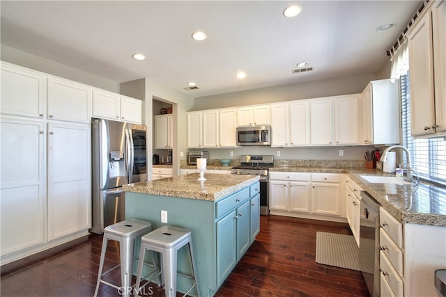 39883 S Creek Cir, Murrieta, CA 92563 - kitchen with appliances with stainless steel finishes, a sink, a kitchen island, dark wood-type flooring, and recessed lighting