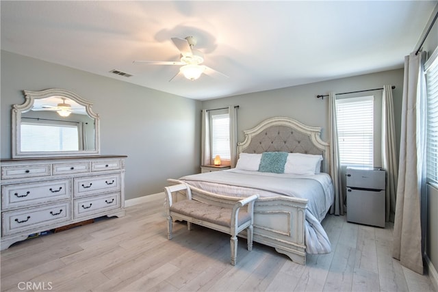 39883 S Creek Cir, Murrieta, CA 92563 - bedroom featuring light wood-type flooring, multiple windows, a ceiling fan, and baseboards