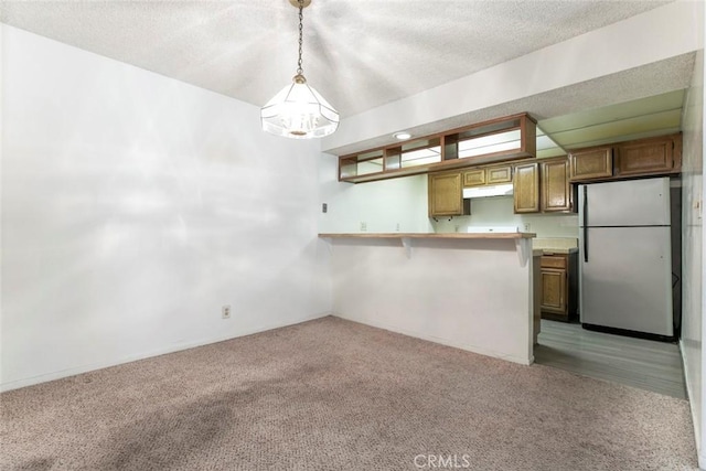 465 Ivy St Unit 203, Glendale, CA 91204 - kitchen featuring freestanding refrigerator, under cabinet range hood, light carpet, a peninsula, and light countertops