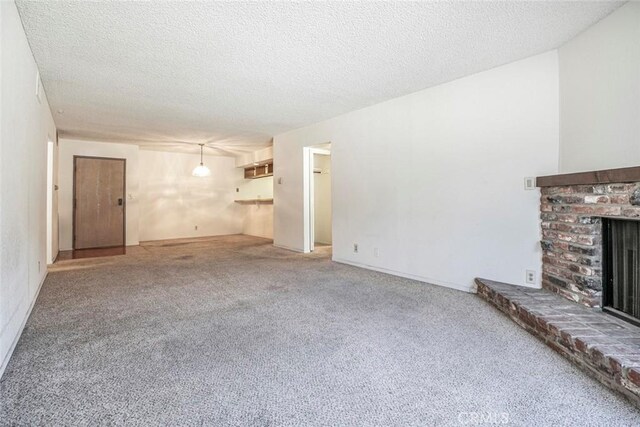465 Ivy St Unit 203, Glendale, CA 91204 - unfurnished living room featuring a brick fireplace, carpet, and a textured ceiling