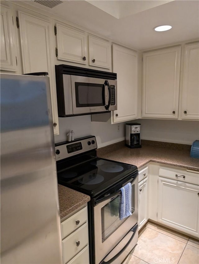 2600 S Palm Canyon Dr S Unit 21, Palm Springs, CA 92264 - kitchen featuring stainless steel appliances, white cabinetry, recessed lighting, dark countertops, and light tile patterned floors