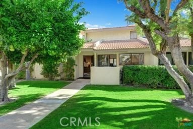 2600 S Palm Canyon Dr S Unit 21, Palm Springs, CA 92264 - view of front of house with stucco siding, a tile roof, and a front lawn