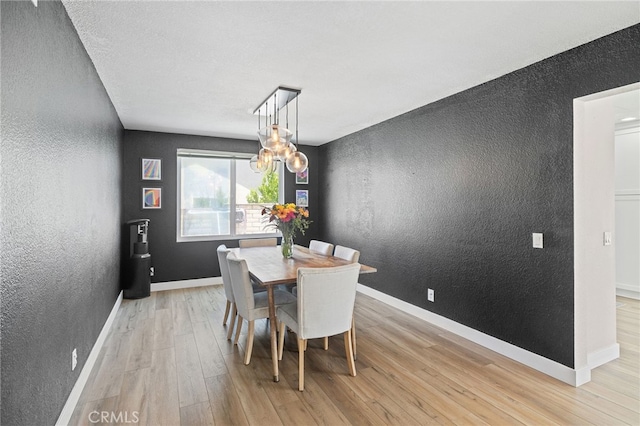 2251 Via Pacifica, Corona, CA 92882 - dining room with a textured wall, light wood finished floors, a chandelier, and baseboards