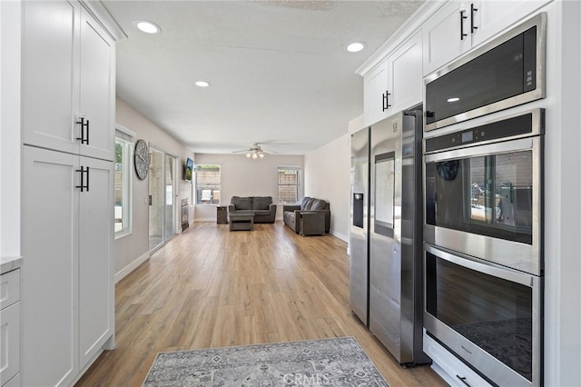 2251 Via Pacifica, Corona, CA 92882 - kitchen with stainless steel appliances, white cabinetry, plenty of natural light, light wood-style flooring, and recessed lighting