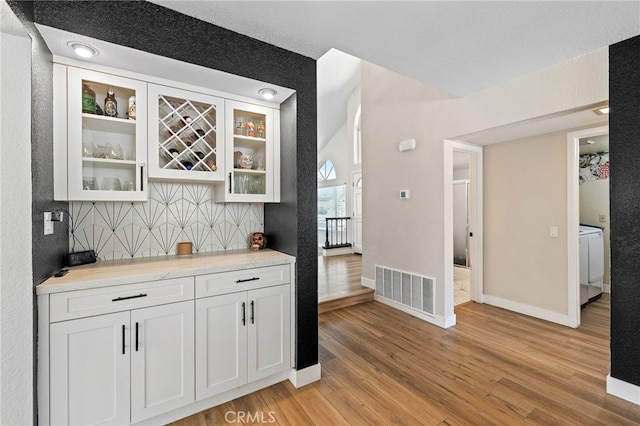 2251 Via Pacifica, Corona, CA 92882 - indoor dry bar featuring light wood-type flooring, tasteful backsplash, baseboards, and washer / clothes dryer