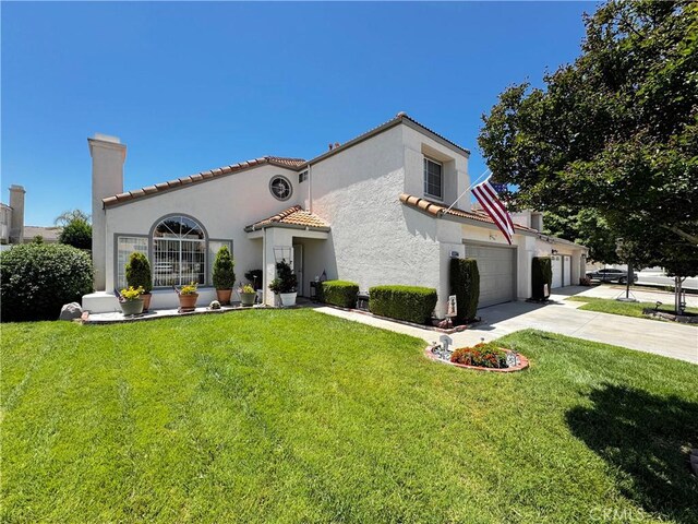 30027 Via Amante, Menifee, CA 92584 - rear view of house with driveway, a chimney, a yard, and stucco siding