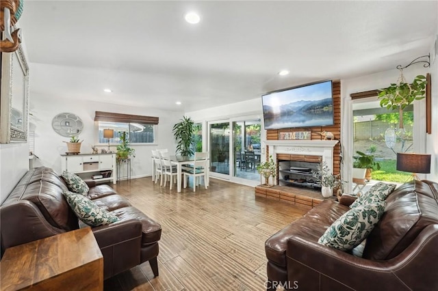 5226 Old Mill Rd, Riverside, CA 92504 - living area featuring a fireplace with raised hearth, healthy amount of natural light, wood finished floors, and recessed lighting