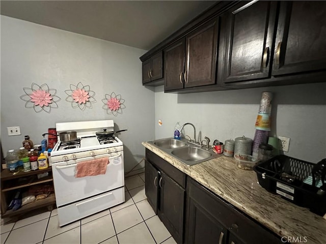 332 S Spring St, Blythe, CA 92225 - kitchen with white gas stove, a sink, and light tile patterned floors