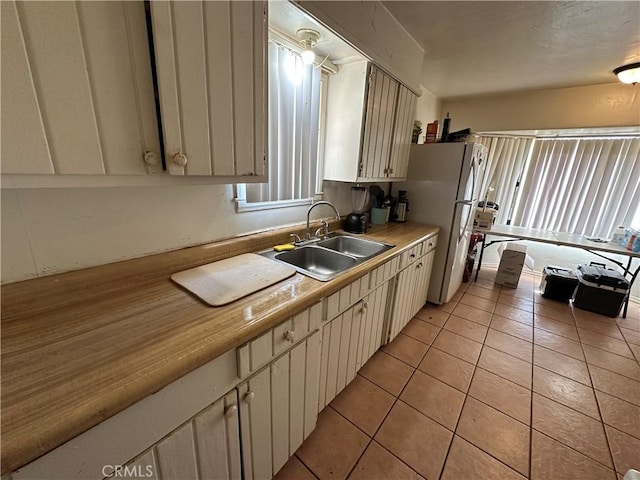 332 S Spring St, Blythe, CA 92225 - kitchen featuring a sink, light countertops, light tile patterned flooring, and freestanding refrigerator