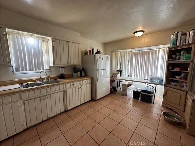 332 S Spring St, Blythe, CA 92225 - kitchen with freestanding refrigerator, a sink, light tile patterned flooring, and light countertops