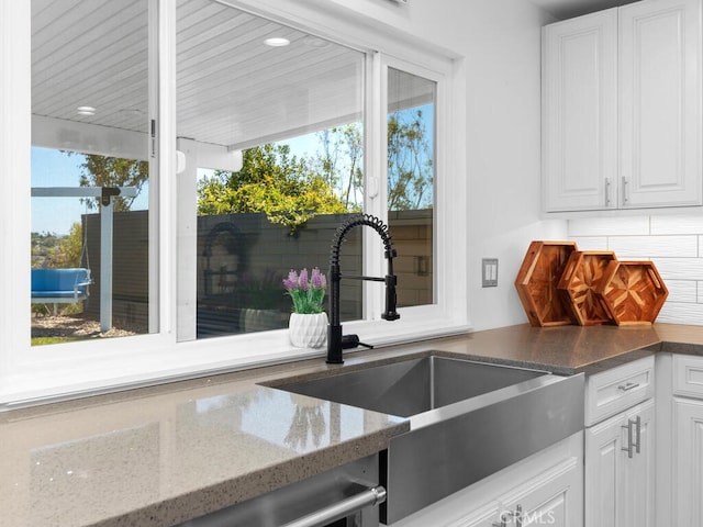 1914 Radford St, Oceanside, CA 92056 - kitchen featuring a sink, white cabinetry, dark stone counters, and decorative backsplash
