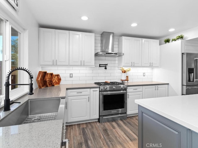 1914 Radford St, Oceanside, CA 92056 - kitchen featuring wall chimney exhaust hood, appliances with stainless steel finishes, a sink, dark wood-style flooring, and white cabinets