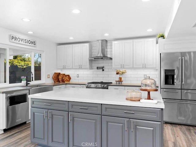 1914 Radford St, Oceanside, CA 92056 - kitchen featuring appliances with stainless steel finishes, wall chimney exhaust hood, a sink, gray cabinetry, and white cabinets