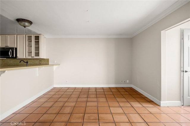 1187 E 3rd St Unit 104, Long Beach, CA 90802 - kitchen featuring stainless steel microwave, decorative backsplash, light countertops, crown molding, and glass insert cabinets