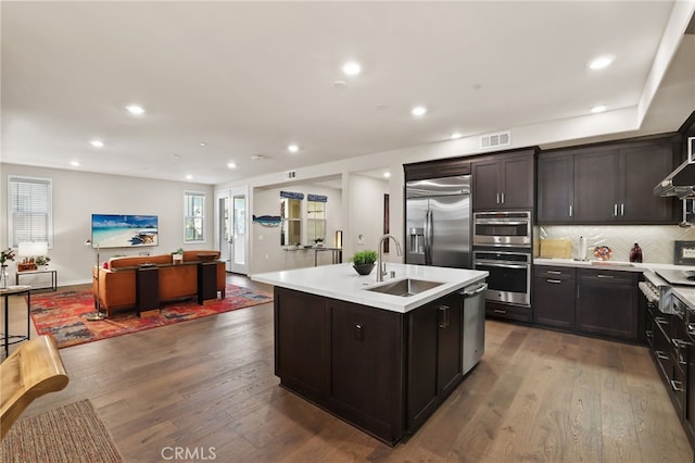 223 Carlow, Irvine, CA 92618 - kitchen featuring stainless steel appliances, a sink, light countertops, open floor plan, and decorative backsplash
