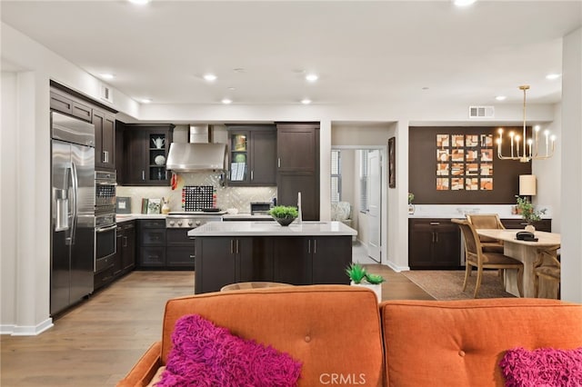 223 Carlow, Irvine, CA 92618 - kitchen featuring wall chimney exhaust hood, appliances with stainless steel finishes, light countertops, decorative backsplash, and recessed lighting