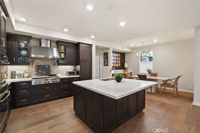 223 Carlow, Irvine, CA 92618 - kitchen featuring a sink, stainless steel gas stovetop, light countertops, decorative backsplash, and glass insert cabinets