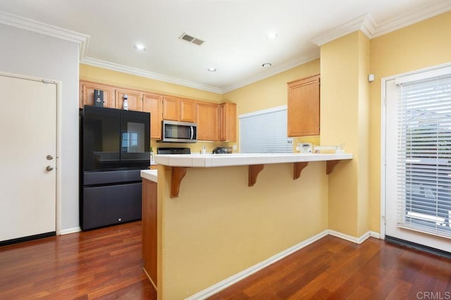 1306 Mill Valley Rd, Chula Vista, CA 91913 - kitchen featuring freestanding refrigerator, stainless steel microwave, dark wood-style floors, a kitchen bar, and crown molding