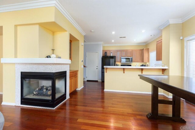 1306 Mill Valley Rd, Chula Vista, CA 91913 - kitchen featuring stainless steel microwave, dark wood-style flooring, a peninsula, light countertops, and a multi sided fireplace