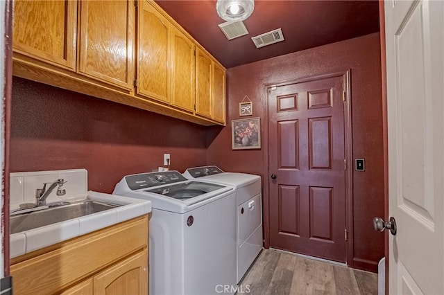 1266 Panorama Point Ct, Merced, CA 95340 - laundry room with washing machine and dryer, cabinet space, and light wood-style flooring