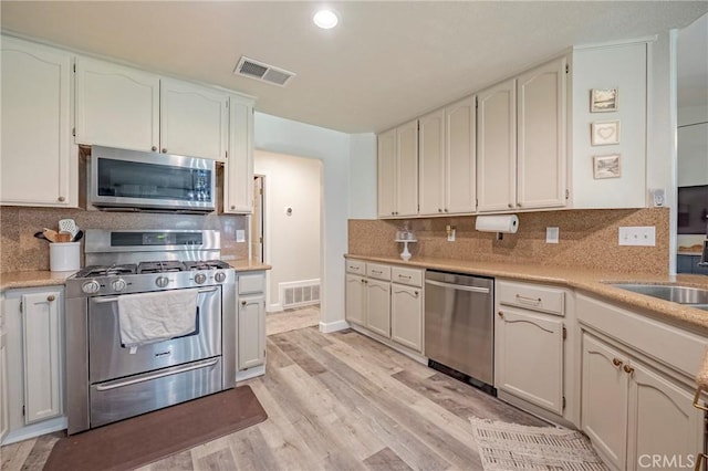 1266 Panorama Point Ct, Merced, CA 95340 - kitchen featuring stainless steel appliances, light wood finished floors, light countertops, backsplash, and recessed lighting