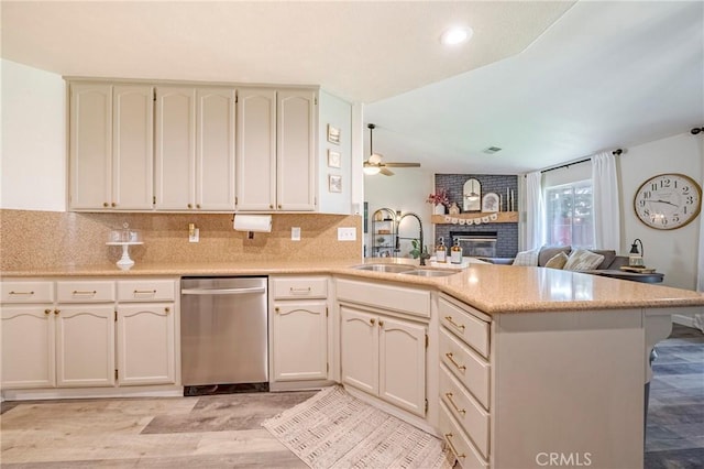 1266 Panorama Point Ct, Merced, CA 95340 - kitchen featuring stainless steel dishwasher, a peninsula, a sink, a fireplace, and open floor plan