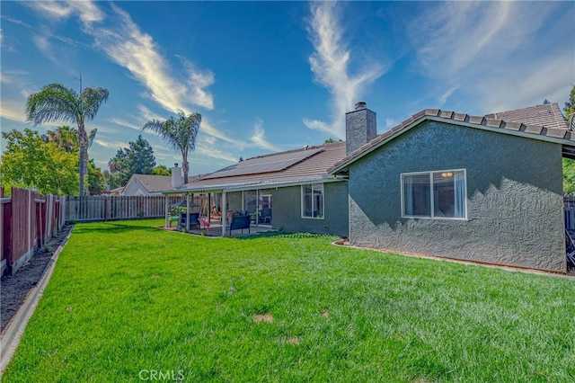 1266 Panorama Point Ct, Merced, CA 95340 - rear view of house featuring stucco siding, a patio area, a chimney, and roof mounted solar panels
