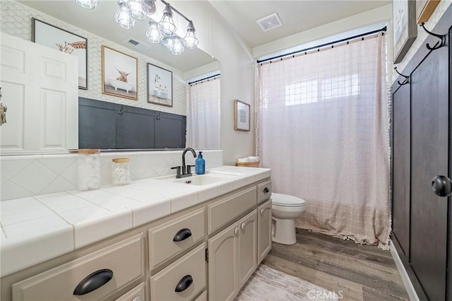 1266 Panorama Point Ct, Merced, CA 95340 - bathroom featuring wood finished floors, toilet, vanity, tasteful backsplash, and curtained shower