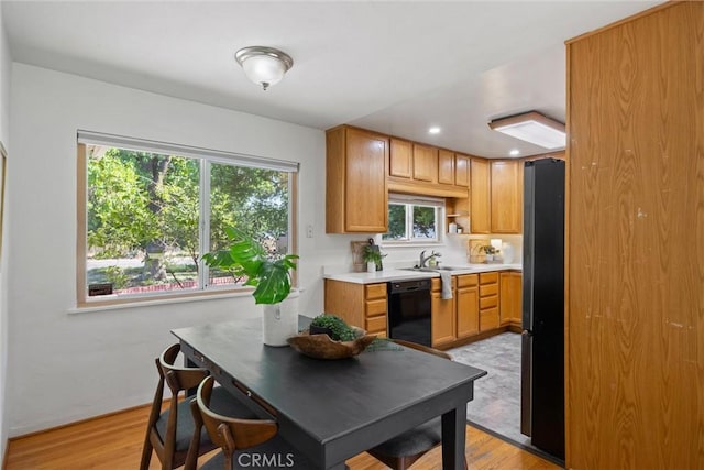 1000 W 11th Ave, Chico, CA 95926 - kitchen with black dishwasher, freestanding refrigerator, light countertops, light wood-style flooring, and recessed lighting