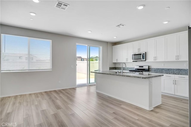 32939 Fleets Rd, Menifee, CA 92584 - kitchen featuring stainless steel microwave, stove, light wood-style floors, white cabinetry, and recessed lighting