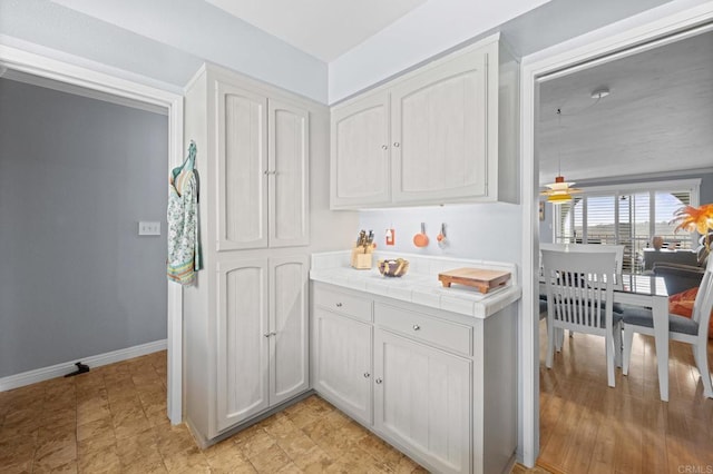 3612 Vista Bella Unit 5, Oceanside, CA 92057 - kitchen featuring tile counters, white cabinetry, and baseboards