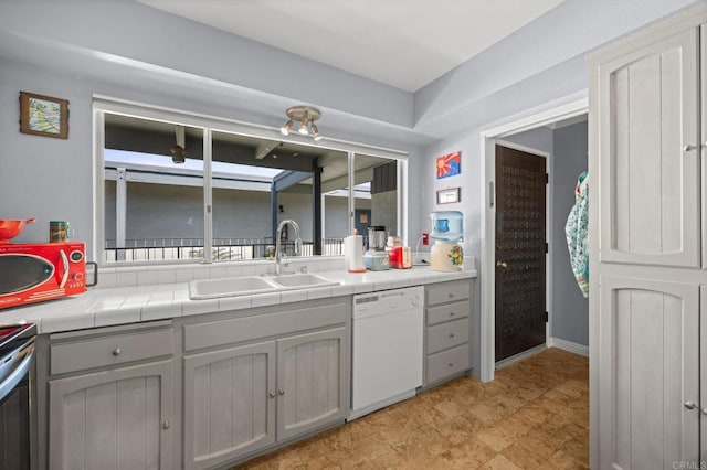 3612 Vista Bella Unit 5, Oceanside, CA 92057 - kitchen featuring dishwasher, a sink, tile counters, gray cabinetry, and baseboards