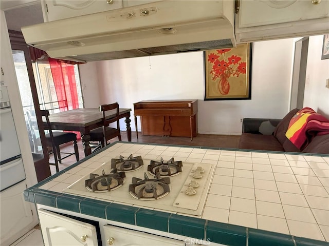 3401 Millbury Ave, Baldwin Park, CA 91706 - kitchen with tile counters, under cabinet range hood, white gas cooktop, and a warming drawer