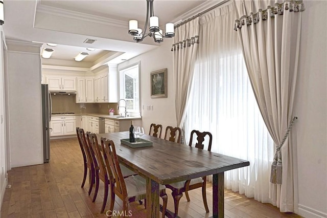 2767 Saleroso Dr, Rowland Heights, CA 91748 - dining space with light wood-style flooring, a chandelier, a raised ceiling, and crown molding