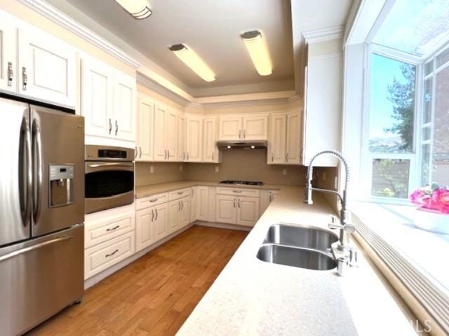 2767 Saleroso Dr, Rowland Heights, CA 91748 - kitchen with stainless steel appliances, under cabinet range hood, a sink, healthy amount of natural light, and crown molding