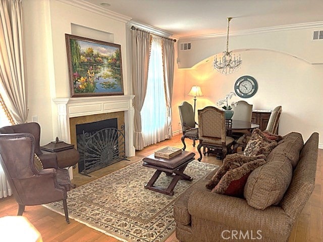 2767 Saleroso Dr, Rowland Heights, CA 91748 - living room featuring a chandelier, wood finished floors, ornamental molding, and a fireplace with flush hearth
