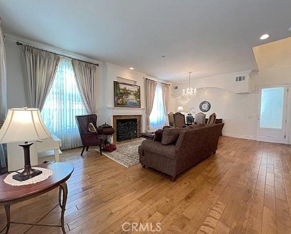 2767 Saleroso Dr, Rowland Heights, CA 91748 - living room with a chandelier, light wood-style flooring, a fireplace, and ornamental molding