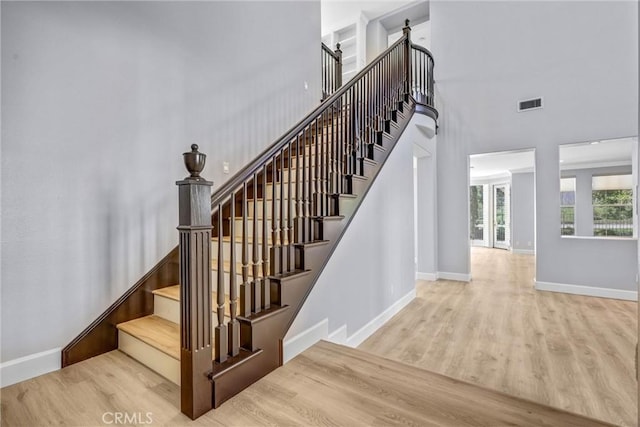 23922 Lakeside Rd, Valencia, CA 91355 - stairway featuring wood finished floors, baseboards, and a high ceiling
