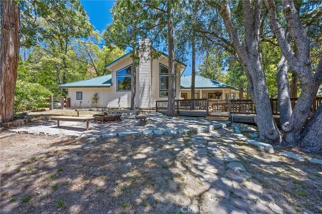 10820 Bonita Way, Wofford Heights, CA 93285 - back of property featuring a chimney, a deck, metal roof, and an outdoor fire pit